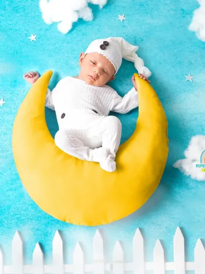 A different take on the moon prop, with a white picket fence adding a whimsical touch to the dreamy sky setup.