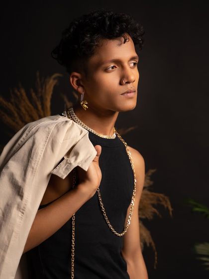 A close-up portrait focusing on my profile and the details of my styling, with the jacket draped over my shoulder.