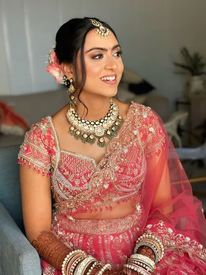 A bright and happy shot of the bride. Her romantic updo is visible from the side, showing the soft texture and floral details.