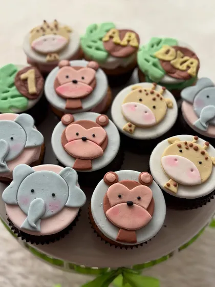 These jungle animal themed cupcakes are a huge hit for first birthdays. Each fondant topper, from the elephant to the monkey, is handmade with care to make the celebration extra cute and memorable.
