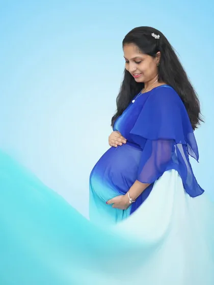 The ombre effect on this blue and white gown is just beautiful. It gives the feeling of a gentle wave, perfect for creating a serene and graceful maternity portrait.