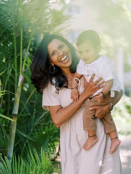 A joyful, candid shot of a mother laughing while holding her son. Her happiness is infectious and makes for a beautiful photo.