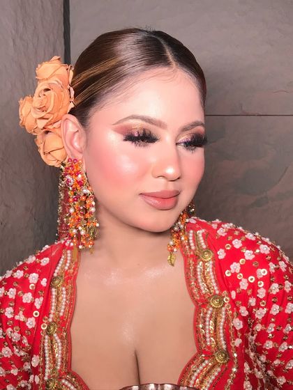 A close-up of the contemporary look, showcasing the soft, blended eyeshadow and the beautiful, oversized floral hair accessory.