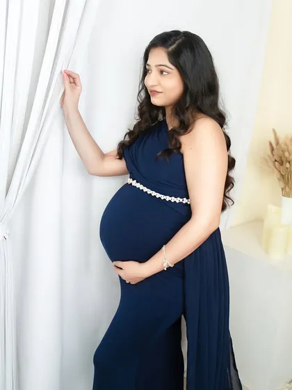 A classic side profile in a beautiful navy blue gown. This pose is perfect for showcasing the curve of your baby bump.
