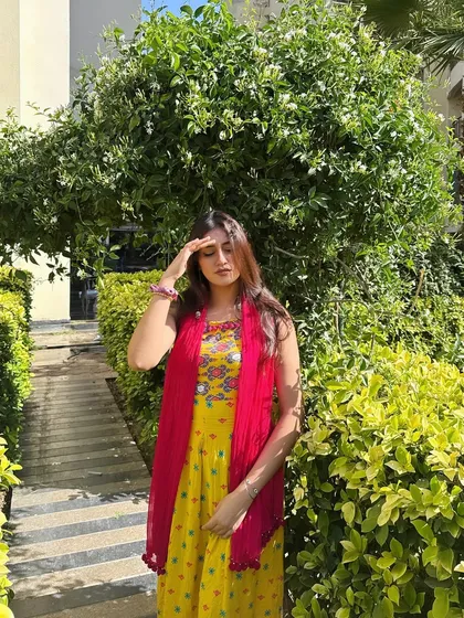 A candid shot in the sun, shielding my eyes. The bright colors of the suit pop against the green background.