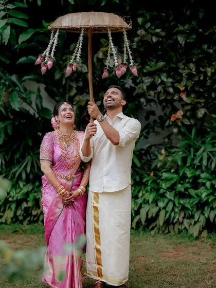 A playful moment under a traditional floral umbrella, the couple's shared laughter making for a perfect candid shot.