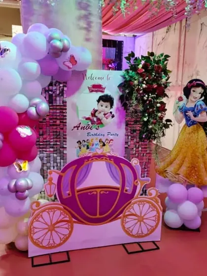 A welcome area for a princess themed party, featuring a Snow White cutout and a beautiful princess carriage prop for photos.