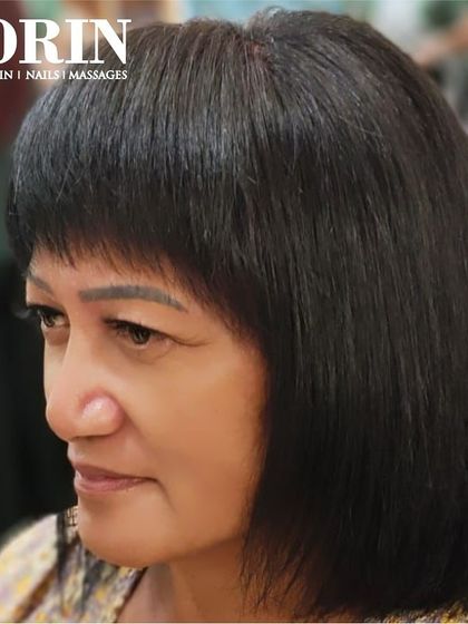 The profile view of a sharp, classic bob with a fringe. This demonstrates the clean lines and expert cutting technique.