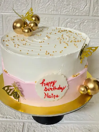 A top-down view of the butterfly and gold ball-accented cake.