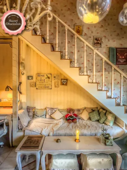 This is my cozy nook under the stairs, a favorite spot for many guests. It’s filled with soft pillows and has a warm, secluded feel, perfect for a dreamy date.