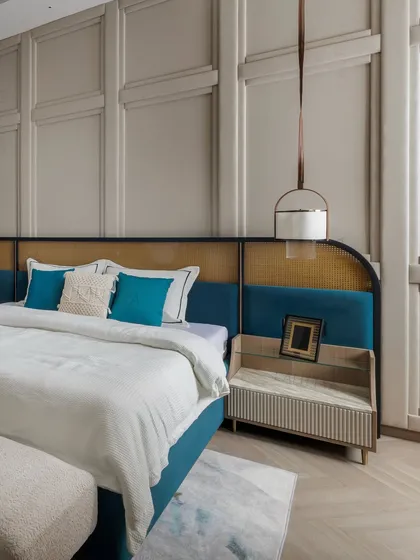 A closer view of the daughter's bed, highlighting the mix of materials on the headboard and the elegant pendant light. The teal cushions provide a fresh, youthful accent.