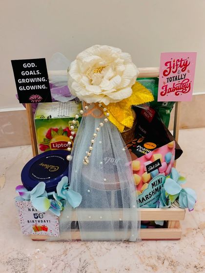 A beautifully arranged 50th birthday hamper. The combination of treats and elegant wrapping makes this a joyful and delicious gift.