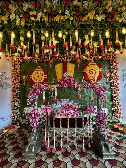 A full view of the cradle and the traditional Tirupati-themed backdrop for a naming ceremony.