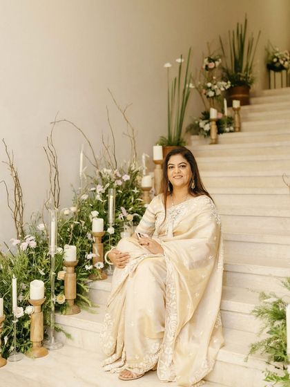 The guest of honor enjoying the elegant decor at her milestone birthday party. We lined the stairs with a mix of fresh florals and candles at varying heights to make the entire space feel special and celebratory.