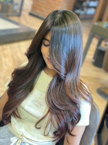 This still image captures the incredible gloss and shine of a fresh brunette color. The subtle warm tones at the ends add just a touch of dimension to the long, healthy hair.