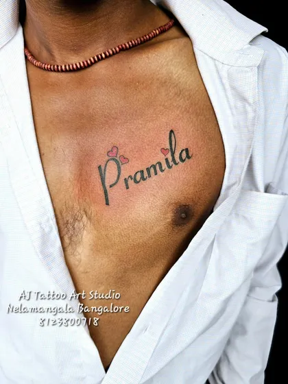 A "Pramila" name tattoo with butterfly-like hearts, placed on the chest.