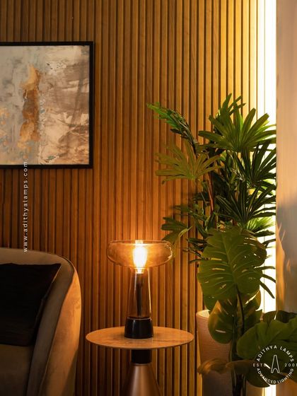 A table lamp can transform a simple corner into a warm sanctuary. This piece, with its amber glass and warm bulb, provides a soft, inviting glow perfect for a side table in a living room or bedroom.