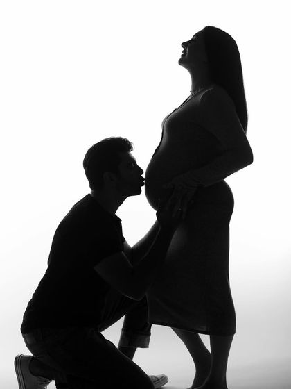 A silhouette capturing the father-to-be's adoration. The contrast of light and shadow makes this a very emotional and artistic way to document the pregnancy.