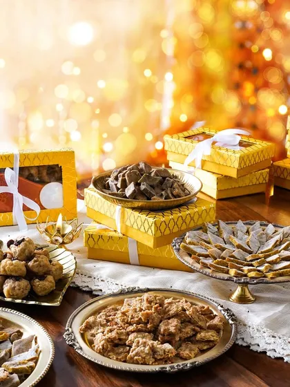 A festive spread of Diwali sweets for dogs, presented in bright yellow gift boxes. This unique and heartwarming concept is perfect for a pet-focused brand.
