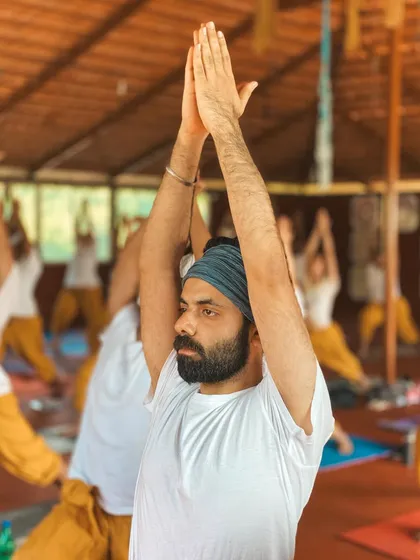 A student holds Warrior I, his focus directed forward. This image captures the strength, stability, and concentration that we cultivate in our asana practice.