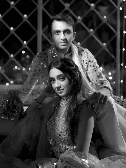 The same moment, captured in classic black and white. This version emphasizes the couple's expressions and the beautiful textures of their outfits, creating a timeless feel.