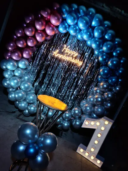 The dramatic lighting on this anniversary setup makes the metallic balloons pop.
