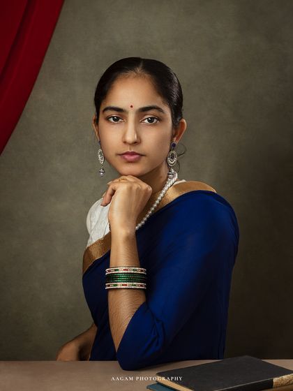 A closer view of the woman in the blue saree, allowing us to appreciate the details of her traditional jewelry and her poised, confident expression.