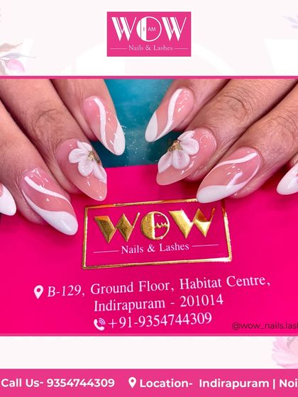 A modern French manicure on almond-shaped extensions. This design features a clean white tip with abstract swirls and 3D floral accents for a unique and artistic touch.