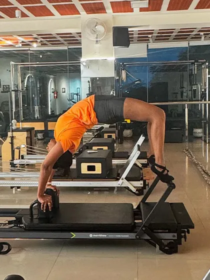 Let's get flexible. This full backbend, or wheel pose, on the reformer demonstrates incredible spinal mobility and shoulder strength.