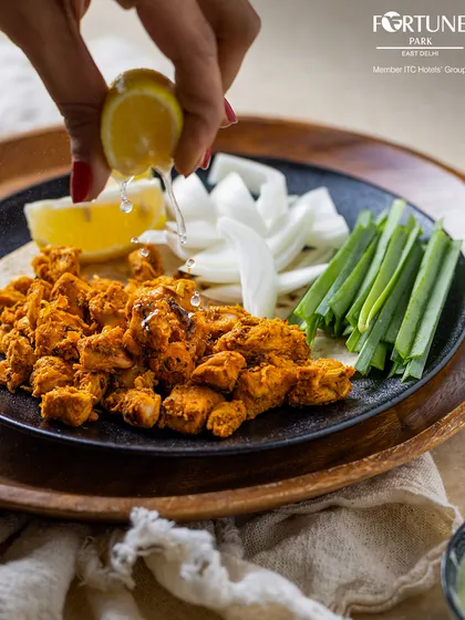 A squeeze of fresh lime over spicy chicken bites, served with sliced onions and spring onions. A simple dish, elevated by fresh ingredients.