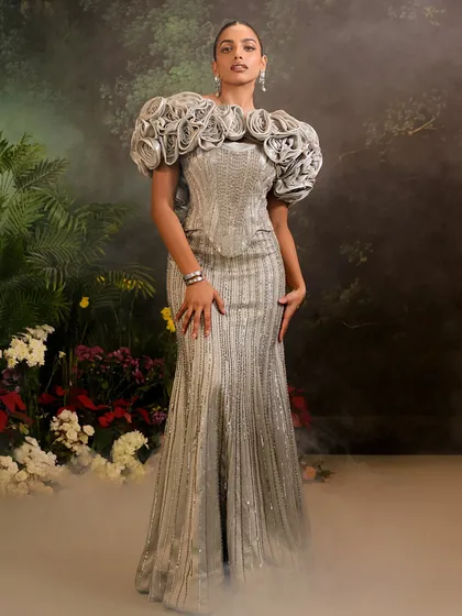 My Bellerose Gown in a shimmering silver, featuring a dramatic 3D floral cape. I designed this piece to be a wearable work of art, blending intricate embellishment with a bold, sculptural silhouette.