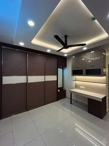 A floor-to-ceiling wardrobe with an integrated study unit is a great way to maximize space in a master bedroom. This design uses a combination of wood grain and grey laminates for a sophisticated finish.
