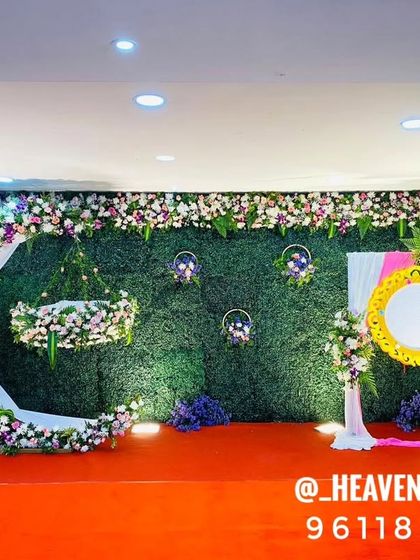 A wider view of our crescent moon swing setup, showing the full stage with a red carpet and side floral arrangements. This design provides a grand and complete look for a naming ceremony or first birthday.