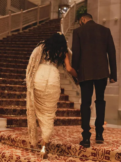 A shot from behind as Anasuya Sengupta and her partner walk up a grand staircase. It tells a story of elegance and togetherness.
