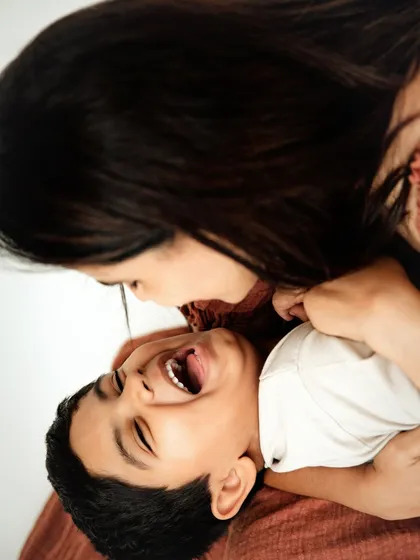 A candid moment of pure laughter between a mother and her son. These playful, ticklish moments create the most authentic and joyful portraits.