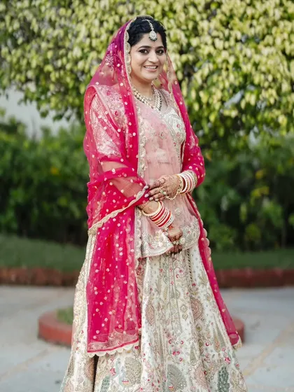 A series showcasing a beautiful sunset wedding look. The bride's makeup is soft and romantic, with a flawless base and defined eyes, perfectly complementing her stunning pastel lehenga for a picturesque Goa wedding.