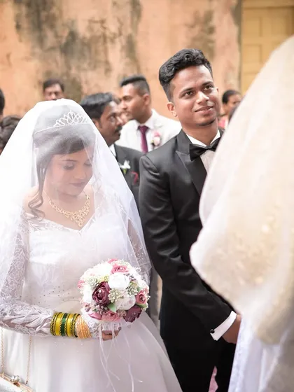 The groom's loving gaze as he watches his bride during their Catholic wedding ceremony. This candid shot captures the profound emotion and commitment of the moment.
