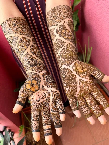 I believe in perfect symmetry for a balanced and beautiful bridal look. Here you can see a matching set of full-arm mehendi, with detailed patterns that are identical on both hands, ready for an engagement ceremony.
