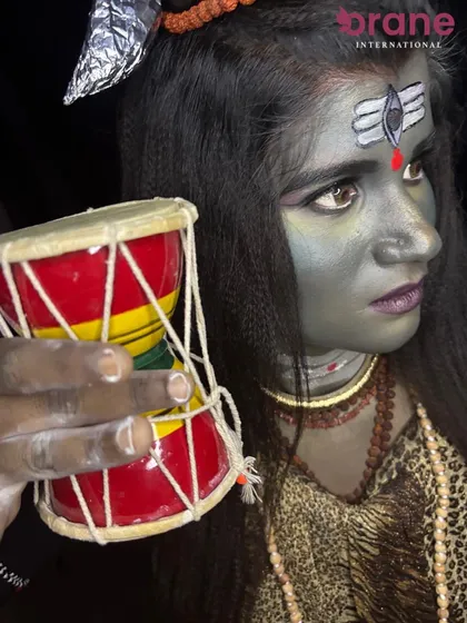 This shot includes the damaru (drum), adding a key symbolic element to the Lord Shiva character makeup.