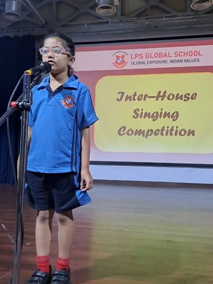 A student sings with focus and passion during her performance. Our music curriculum helps students develop their vocal skills and musicality.