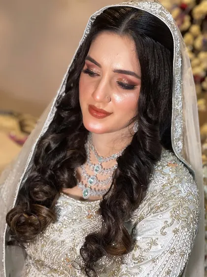 A beautiful, ethereal look for this bride in a light grey-blue outfit. The makeup is soft and shimmery.