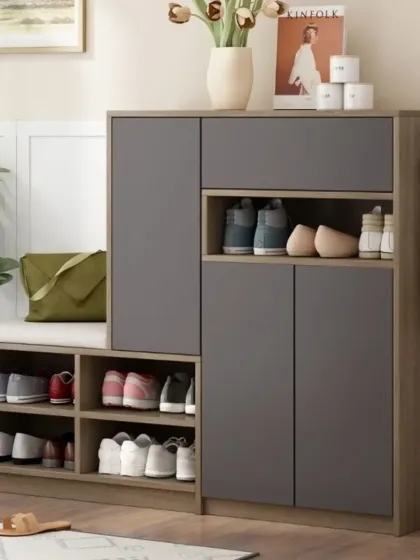 A compact and modern shoe storage cabinet with a cushioned seating area. This piece combines open cubbies for everyday shoes and closed cabinets for a tidy look.