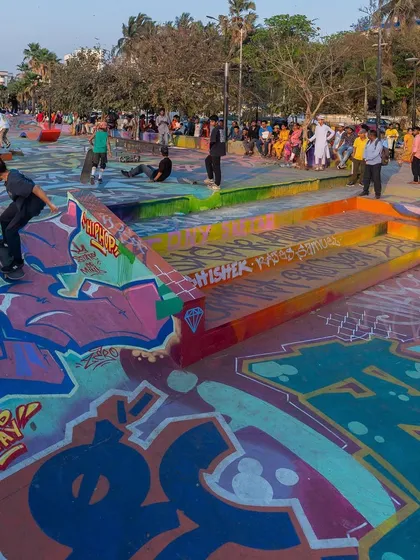 The finished skatepark full of life, with skaters and locals enjoying the new, colorful environment. The art is complete when the community activates it.