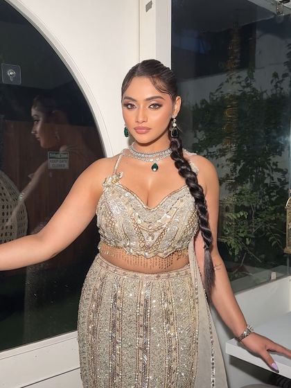 A front view of the model showcasing the sleek twisted braid. The hair is pulled back cleanly to highlight the face, while the braid adds a touch of modern sophistication.