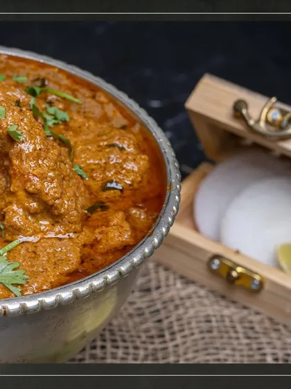 Our Mutton Korma, served with fresh onions and lime, highlighting the traditional way of enjoying this classic dish.
