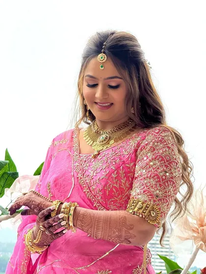 A close-up showcasing the soft glam makeup and half-up hairstyle for this bride in pink. The look is designed to photograph beautifully while feeling lightweight and comfortable.