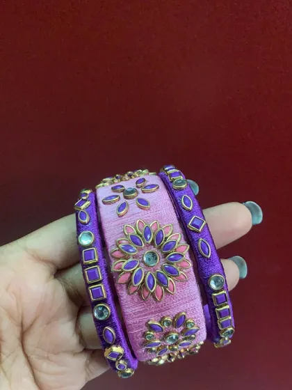 A collection of my pink silk thread bangles, showcasing a variety of designs from simple geometric patterns to elaborate floral kundan work.