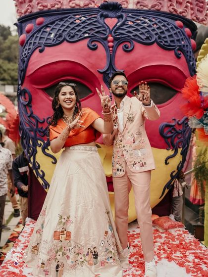 The couple waving to their guests from the stage at their grand carnival-themed celebration.