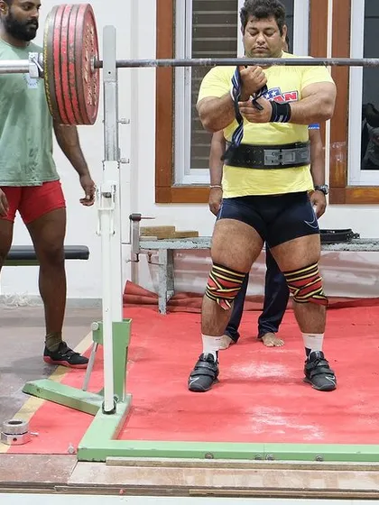 Adjusting my wrist wraps before a heavy squat at the railway camp. Every detail of the setup matters for a successful lift.