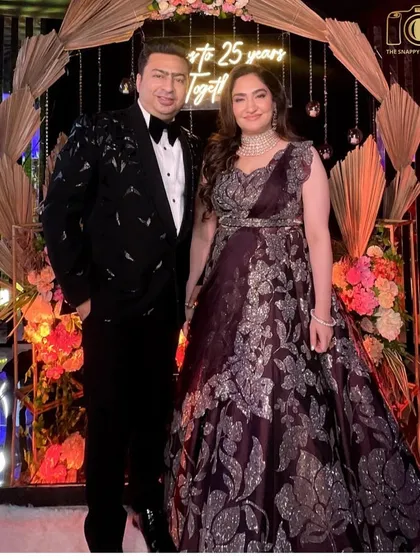 Celebrating a silver jubilee! The happy couple marking 25 years together, looking absolutely regal in front of a custom backdrop.